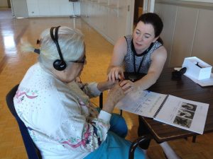 A participant tries an amplification device during a Toronto HEARS session