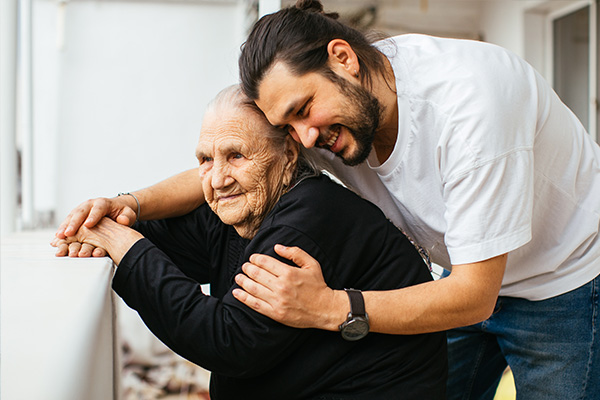 Supporting-caregivers-from-ethnocultural-communities image of elderly lady in wheelchair being hugged by carer