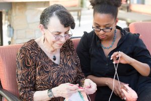 Grandmother and granddaughter knitting together 